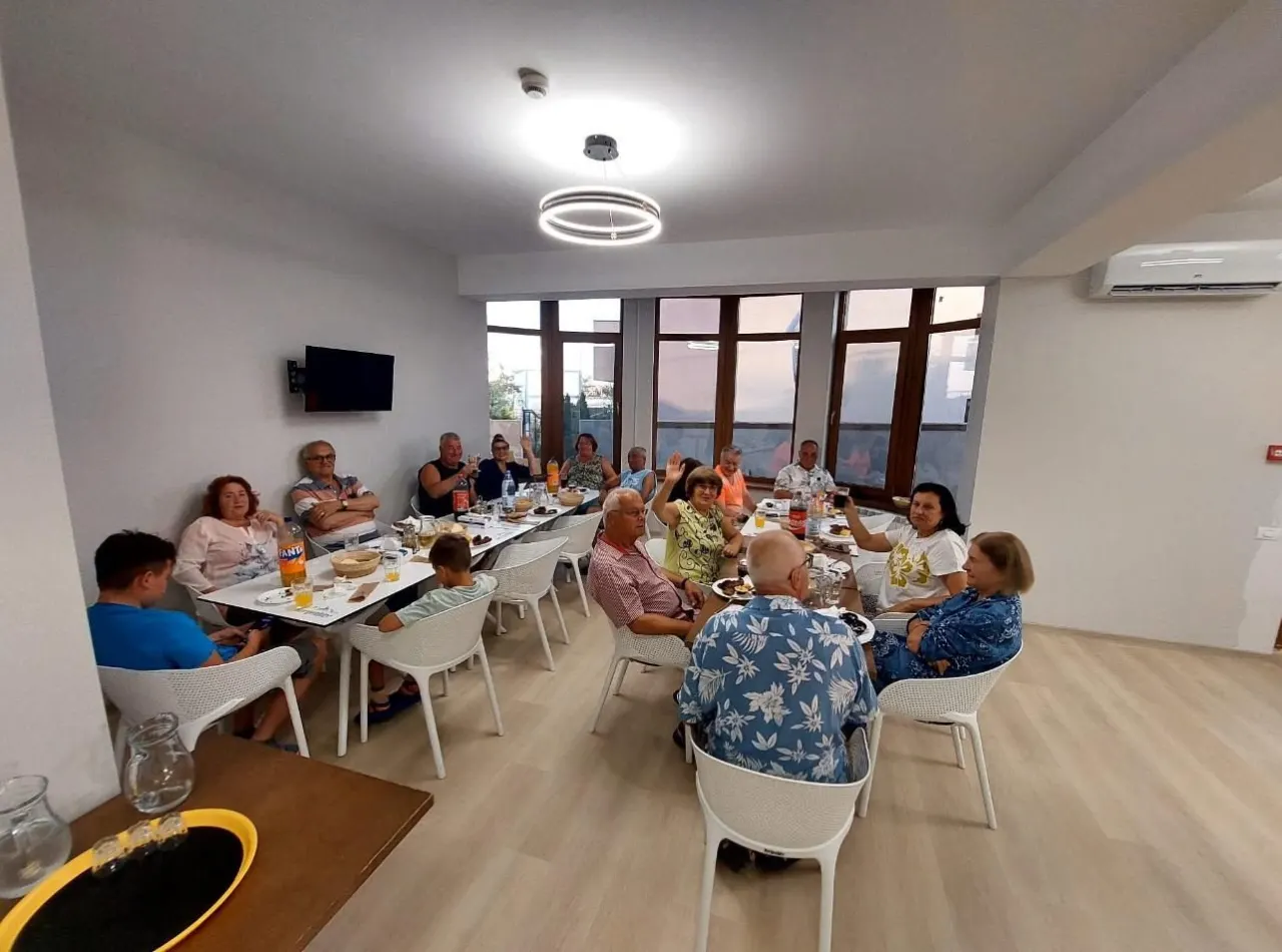 Oaspeții la masa festivă din restaurantul hotelului